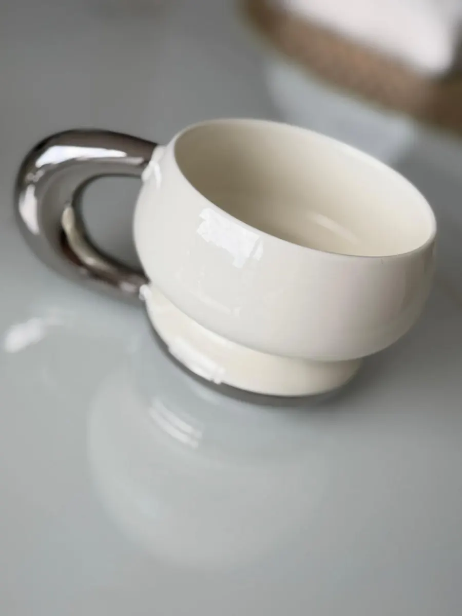 Taza cerámica blanca asa metálica plateada